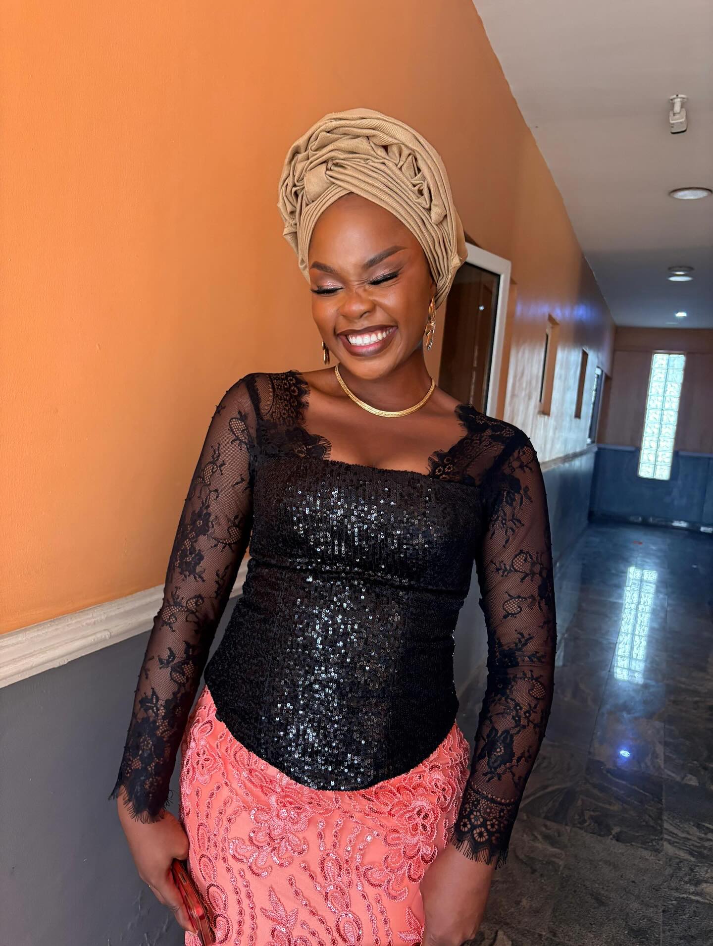 Black sequin lace top over coral aso-oke skirt.